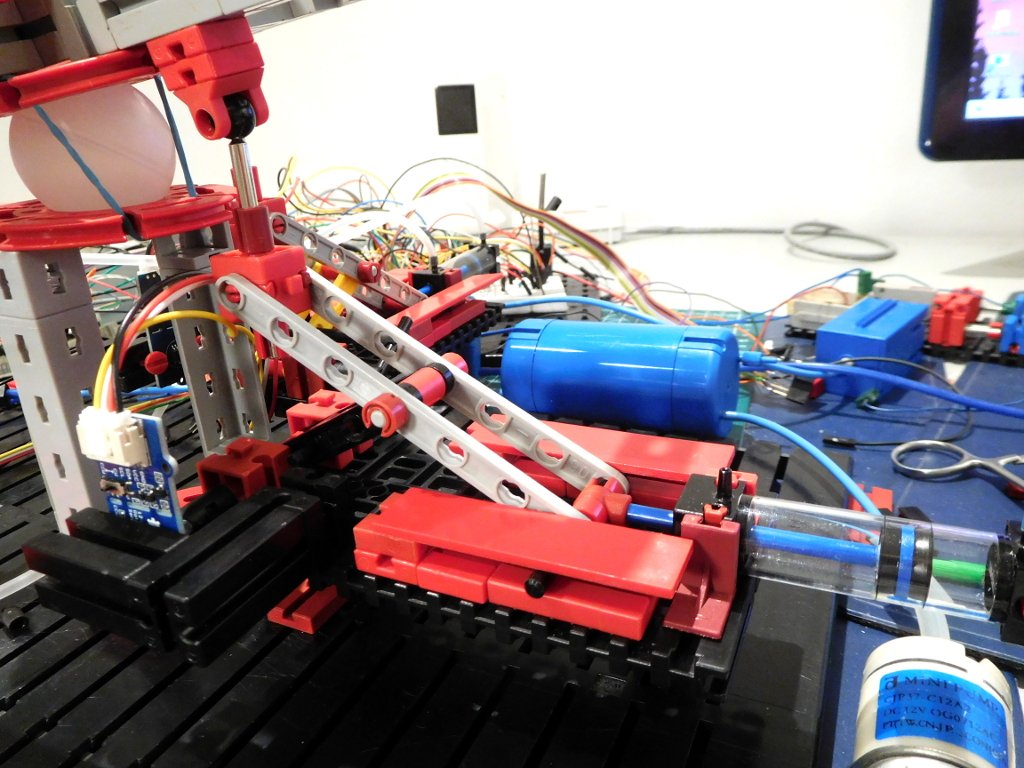Pneumatische Kipp-Ansteuerung einer Ebene mit symmetrischer Schubkurbel. Die Drehung des kleinen schwarzen Hebels (4 Löcher) wird mit einem magnetischen AS5600-Winkelencoder (links vorne, blau) gemessen.